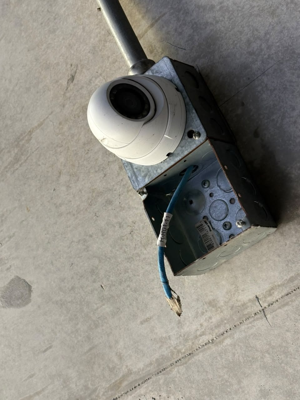 Cámara junto a una caja abierta y cable expuesto